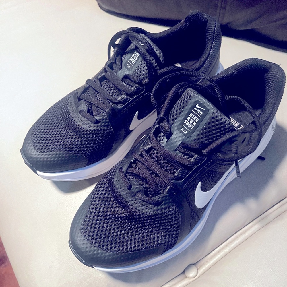 Women’s Nike running shoes black with white swosh in excellent condition.